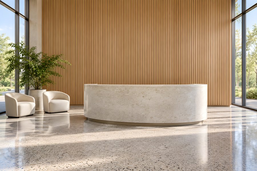 Empty modern office reception with curved stone desk, wood slat feature wall, and cream armchairs in a bright corporate lobby