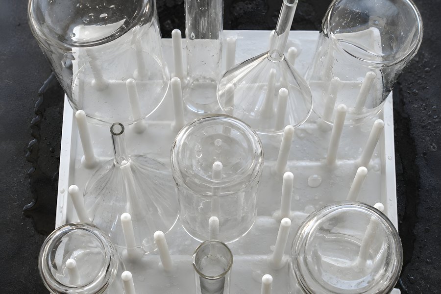 Empty Laboratory Beakers, Test Tube and Glass Funnel Drying on a Pegboard Rack, Overhead View