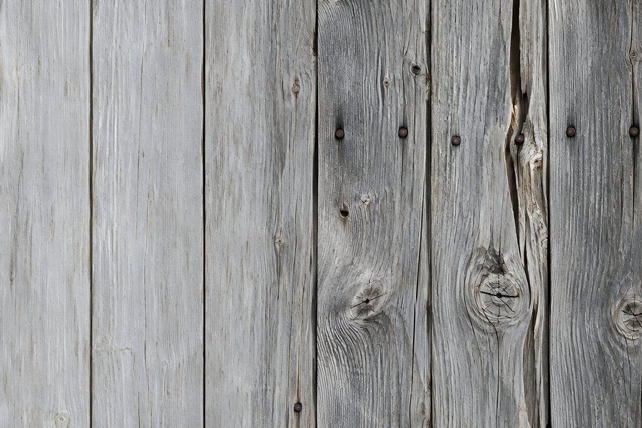 Weathered gray wood plank wall texture with knots and rusty nails, rustic barn siding background