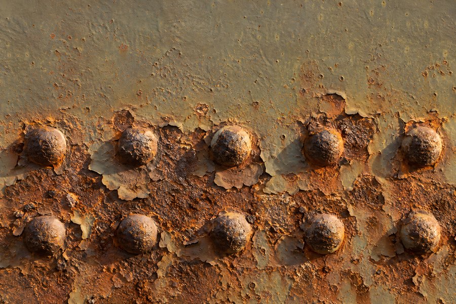 Rusted Riveted Steel Plate with Peeling Olive Paint and Orange Corrosion Texture