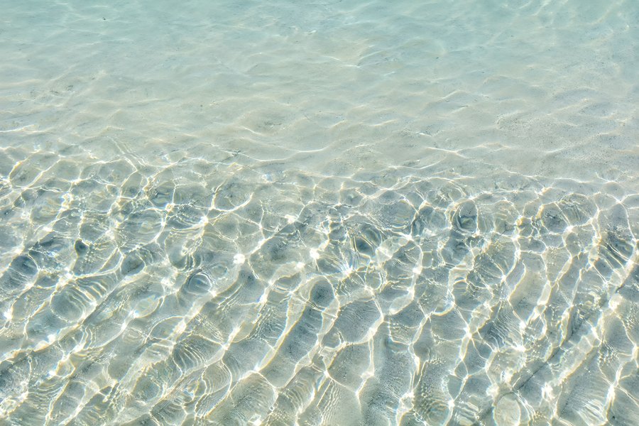 Aerial View of Shallow Clear Water with Sunlight Caustics Rippling Over Pale Sandy Seabed