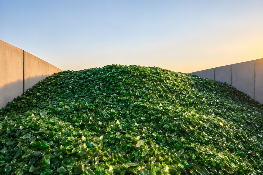 Mound of Crushed Green Glass Cullet in a Concrete Recycling Bunker at Sunset