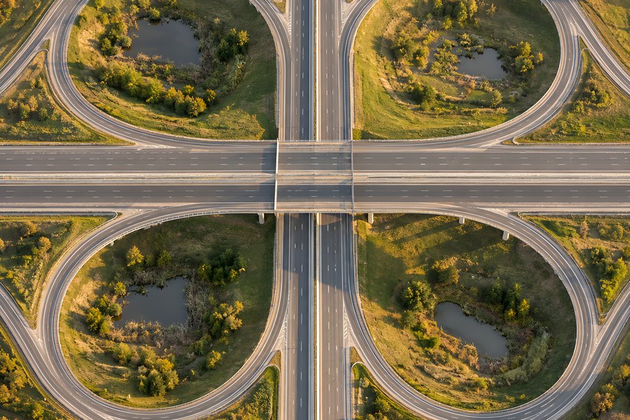 Aerial View of Empty Cloverleaf Highway Interchange with Overpass Bridge and Wetland Ponds