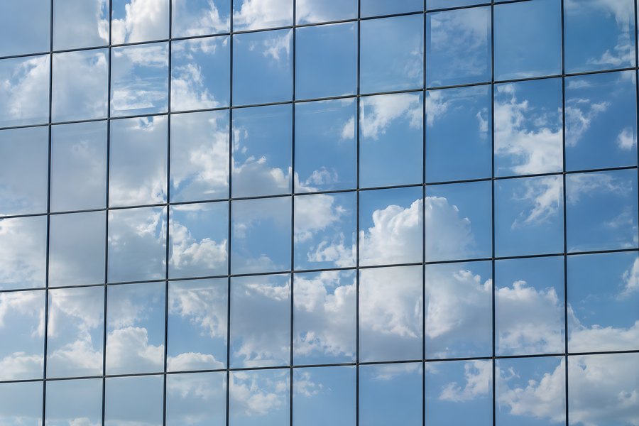 Blue Sky and Clouds Reflected in a Modern Glass Curtain Wall Office Facade