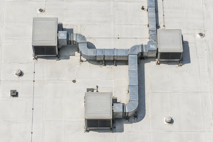 Aerial top-down view of a flat industrial roof with HVAC units and connecting ductwork