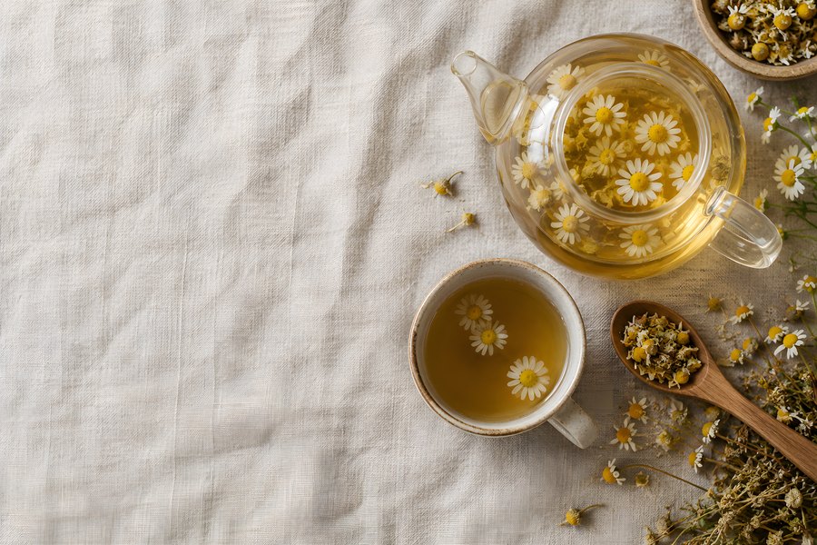 Chamomile Herbal Tea Flat Lay with Glass Teapot, Ceramic Cup and Dried Flowers on Linen Background